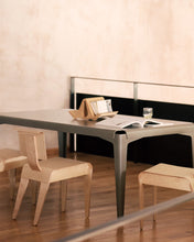 Load image into Gallery viewer, Isokon Gull sitting on a grey table surrounded by Isokon plywood dining chairs